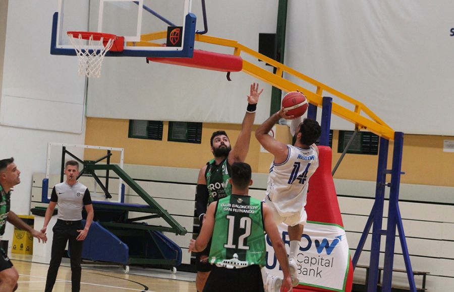 Fede Ristori, del Ciudad de Huelva, lanza ante la oposición del pívot del Cimbis Pepe Ruiz durante el primer cuarto del partido.
