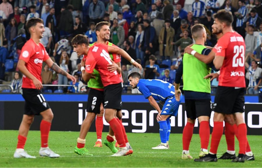 La alegría del San Fernando CD tras el pitido final del colegiado contrasta con la desolación del jugador del Deportivo.