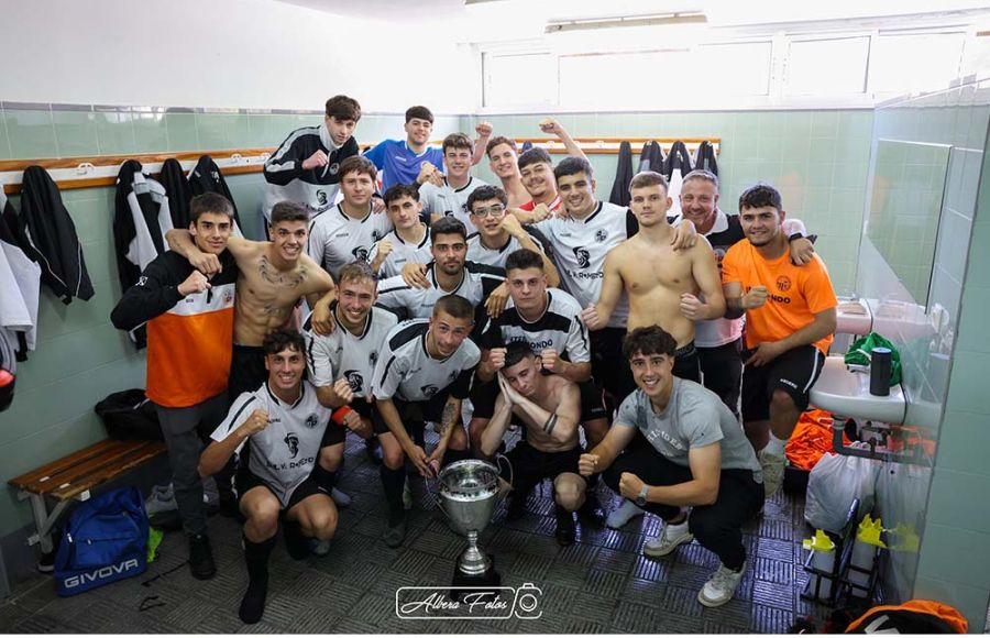 El San Fernando Atlético posa con la copa de campeón en el vestuario de Gómez Castro.