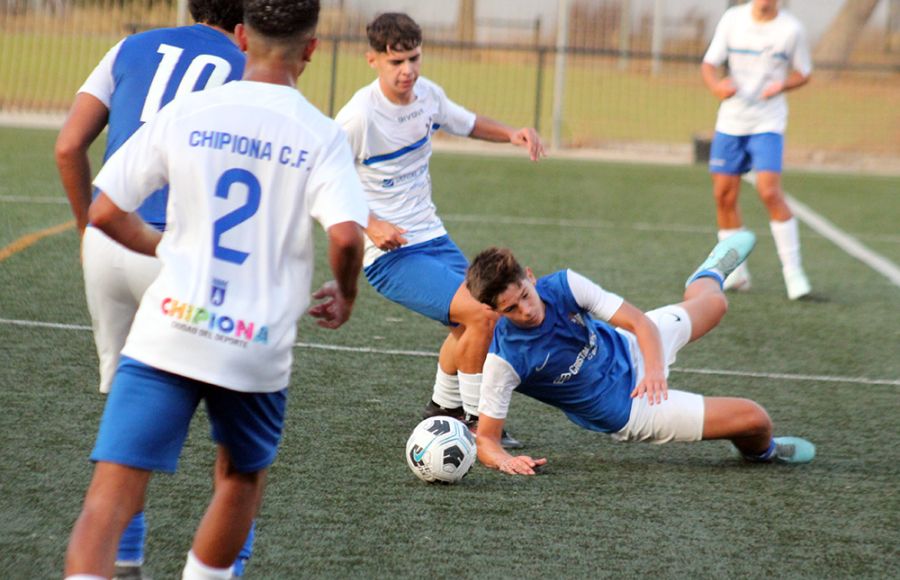 Hugo Méndez, mediocentro de la Escuela Bahía, es objeto de falta por parte de un jugador del Chipiona. 