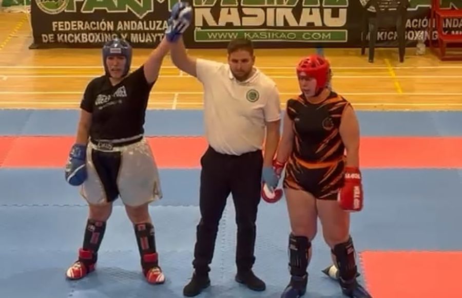 El árbitro levanta el brazo de Cristina tras ser la ganadora del combate. 