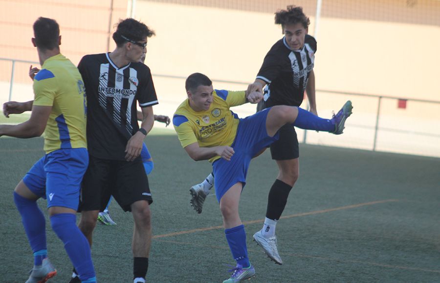 El central del San Fernando Atlético, Aure García, se anticipa a un rival y despeja un balón en presencia de su compañero Álex Peña. 