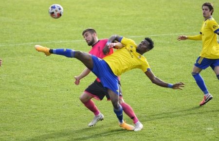 Francis Ferrón pugna por un balón con el defensa nigeriano del Cádiz B, Saturday y abajo aparecen los técnicos Jovan Stankovic y Juanma Pavón.