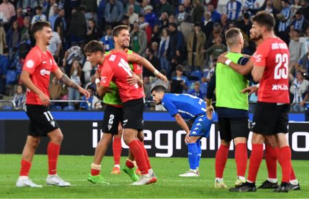 La alegría del San Fernando CD tras el pitido final del colegiado contrasta con la desolación del jugador del Deportivo.