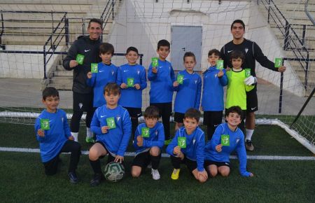 Los prebenjamines de la Escuela Bahía y su tándem técnico muestran la tarjeta verde