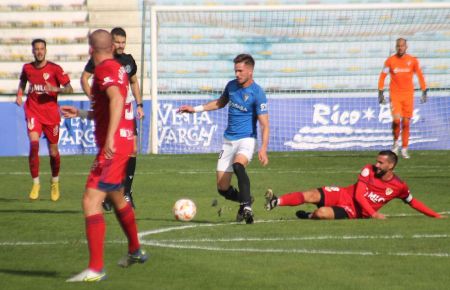 José Carlos, que regresa tras su lesión, supera al capitán del Linares Rodri en Bahía Sur y con Lolo González, ausente por lesión, atento a la jugada.