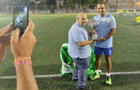 Carlos Cuenca, capitán del Conil CF, recibe el trofeo de campeón de manos de Victoriano Gil. 