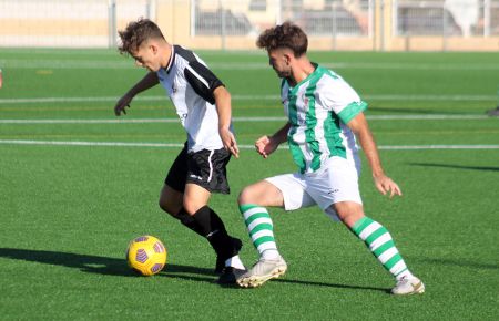 Hugo Capote, del San Fernando Atlético, controla el balón ante un jugador del Puerto Real en la apertura del Memorial Paco Armario. 