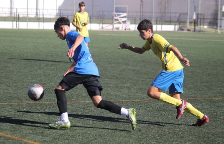 Mario del Valle, del infantil A del San Fernando CD, se marcha de un jugador de la UD Tomares.