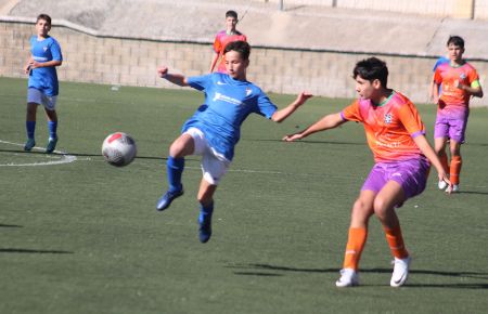 Hugo Rodríguez, del infantil B del San Fernando CD, que lidera el grupo 2 de Tercera Andaluza, intenta cazar un balón ante el Sporting Puertorrealeña.