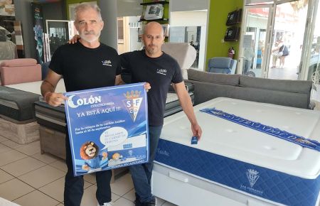 Manuel Andreu y David Montañez muestran el cartel de la promoción junto al colchón.