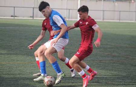 José Pedraza forcejea con dos jugadores del Sevilla FC. 