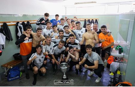 El San Fernando Atlético posa con la copa de campeón en el vestuario de Gómez Castro.