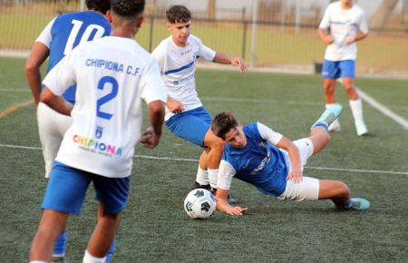 Hugo Méndez, mediocentro de la Escuela Bahía, es objeto de falta por parte de un jugador del Chipiona. 