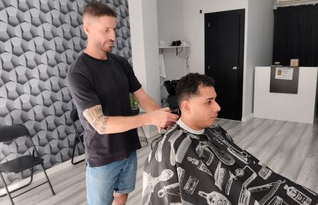 Juanje Torrejón atiende a un cliente, el pasado martes, en su peluquería situada en la avenida Manuel de Falla. 