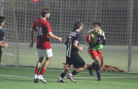 El meta del San Fernando Atlético juvenil, Adrián Mellado, bloca un balón ante su compañero Rubén Fariñas y el defensa del CDSF, Juanan Braza. 